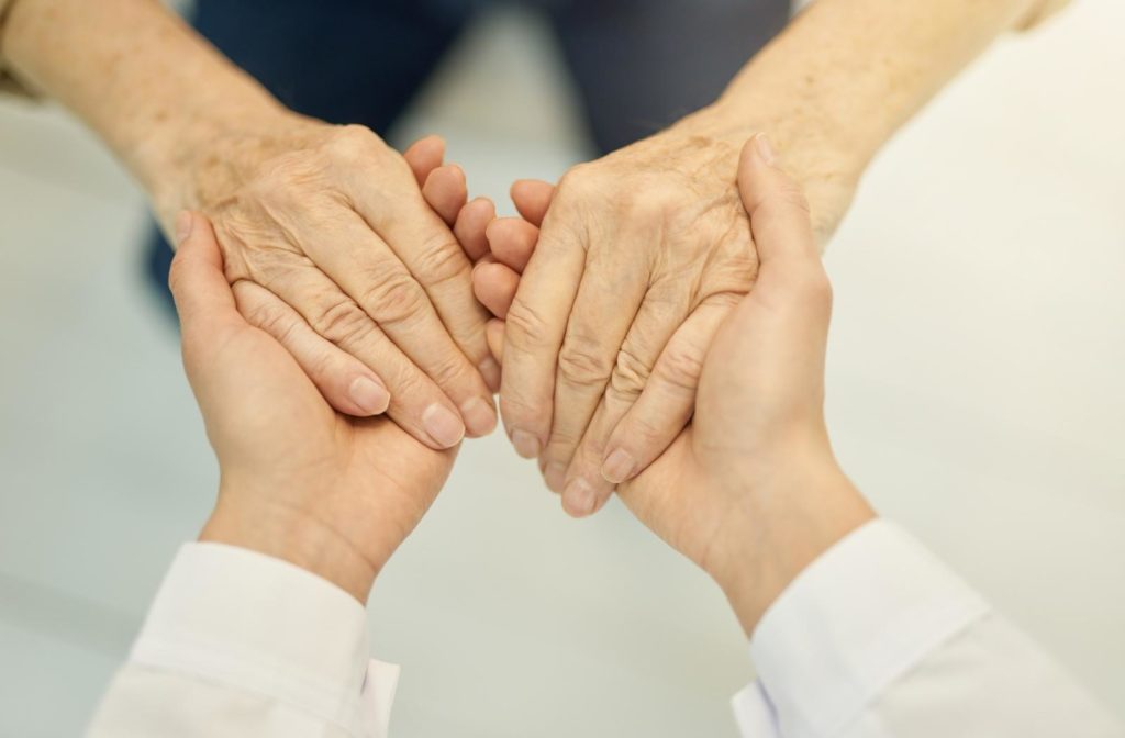 A caregiver holding the hands of a senior