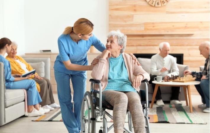 A nurse assisting an elderly lady in a nursing home