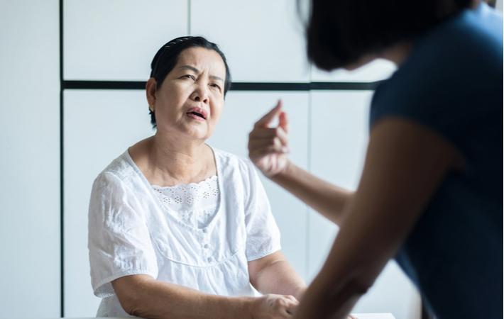 A senior woman who has Alzheimers confused with remembering someone's face in a conversation