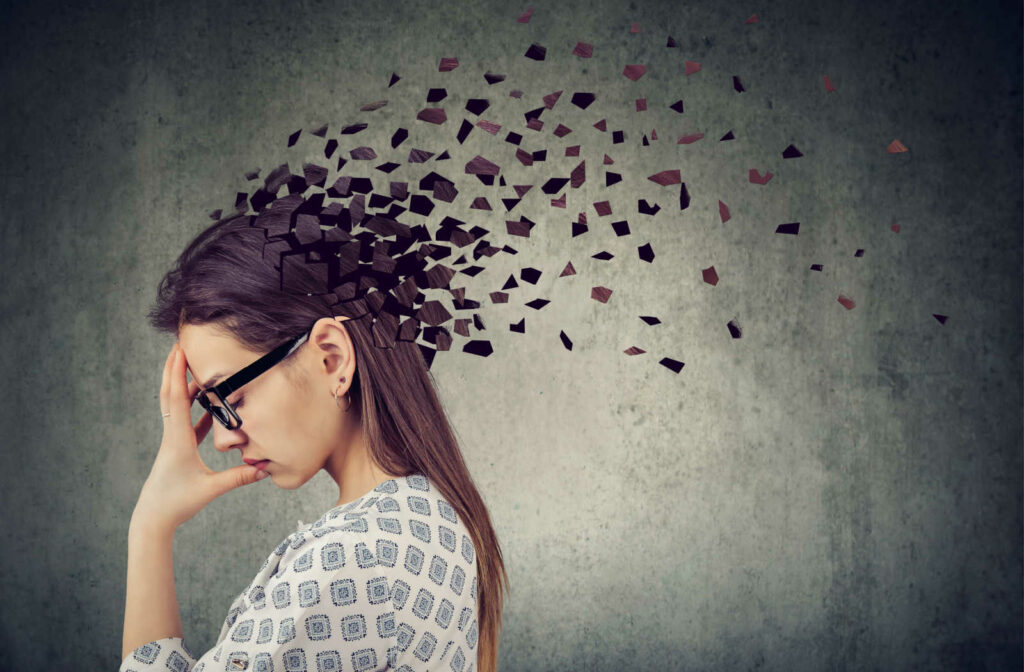 A female young adult touching her head with a fading effect on her head is a symbol of fading memory.