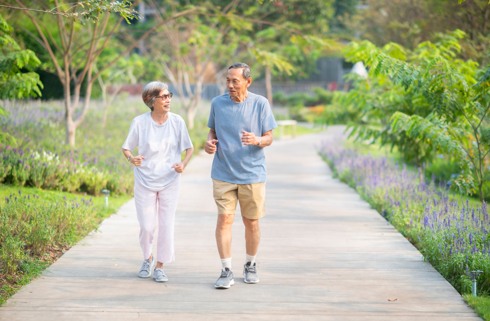Mature man and woman jogging in a park.