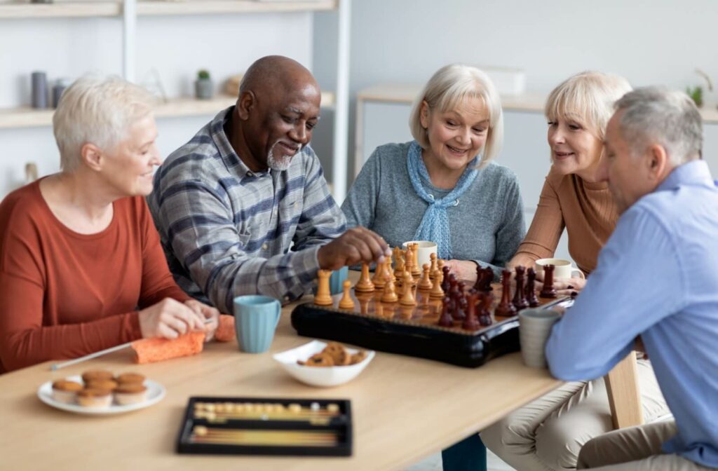 A group of seniors enjoying a game of chess together with their peers at a senior living community.