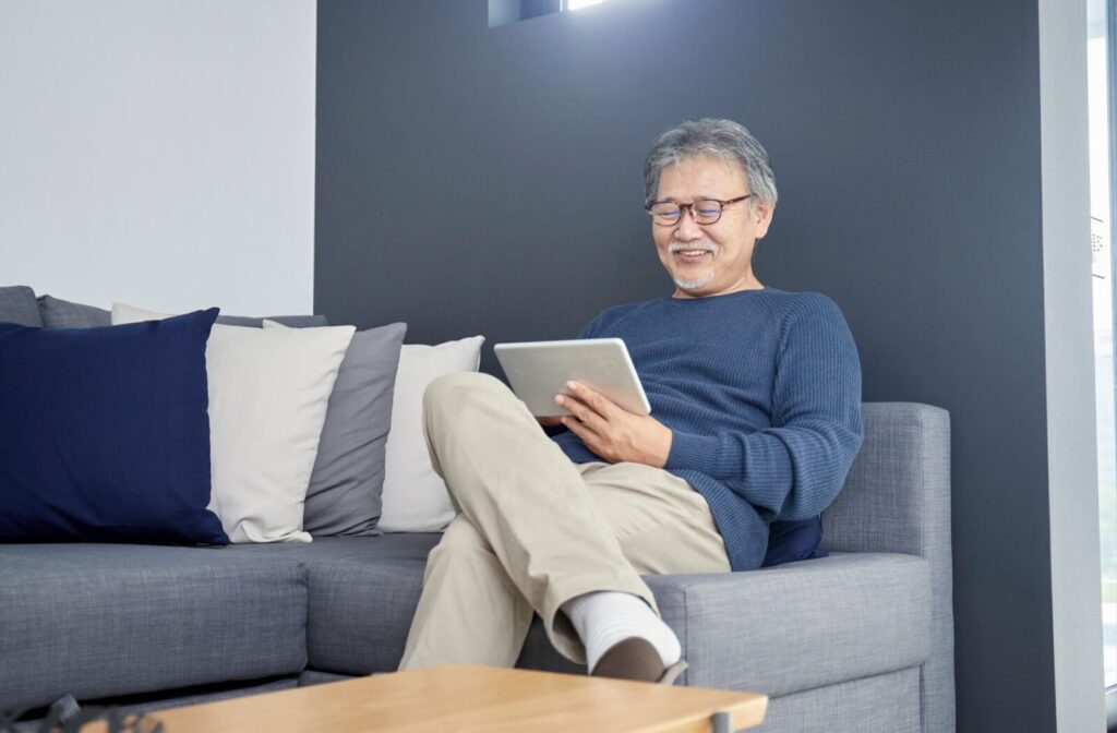 An older adult uses their tablet to stay connected with their family.