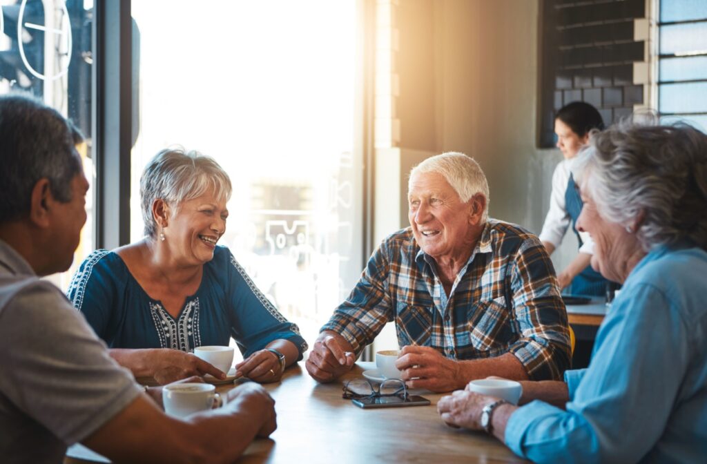 A group of senior friends enjoy a conversation over coffee together.