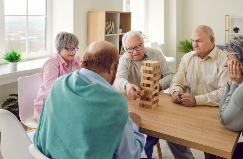 A group of seniors play a game of jenga at an independent living community.