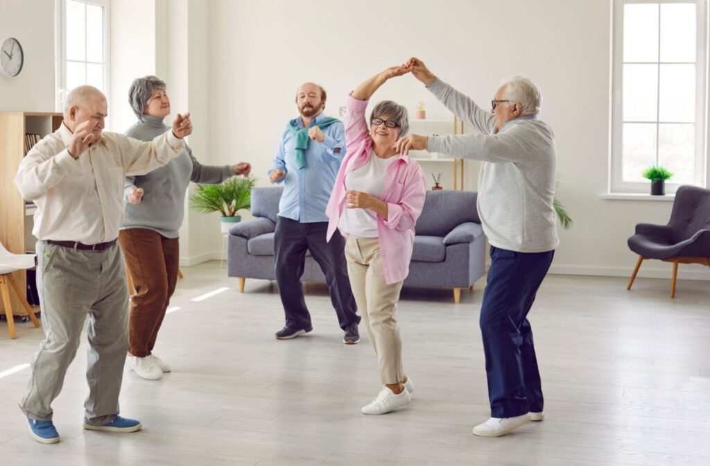 A group of senior residents participate in a light, low-impact dance class.